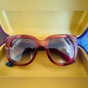 Brown Gucci sunglasses with purple velvet sunglasses holder.